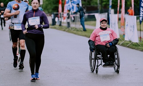 biegacz i uczestniczka na wózku inwalidzkim