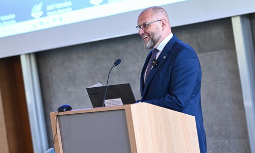 Prorektor Andrzej Myśliwiec stoi przy mównicy, wygłaszając przemówienie.